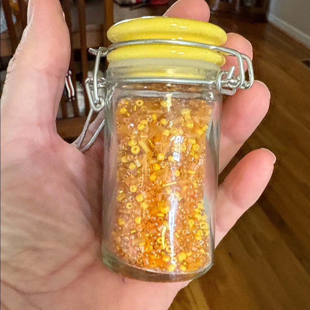 Small Glass Canister filled with yellow and orange seed beads